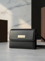Maison Arlen Legacy Bag Black Edition front view with gold Maison Arlen plaque on marble background