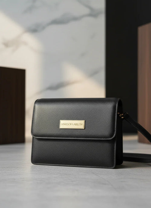 Black handbag with a visible brand logo on a light surface.